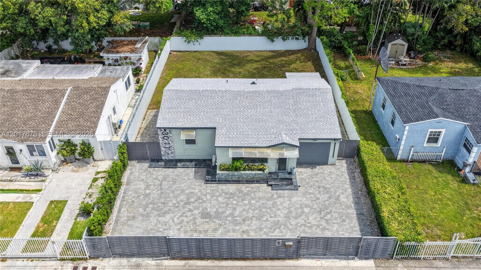 An aerial view shows a single-story house with a paved driveway and a fenced backyard — 1130 NW 57th St, Miami FL 33127, MIAMI, FL