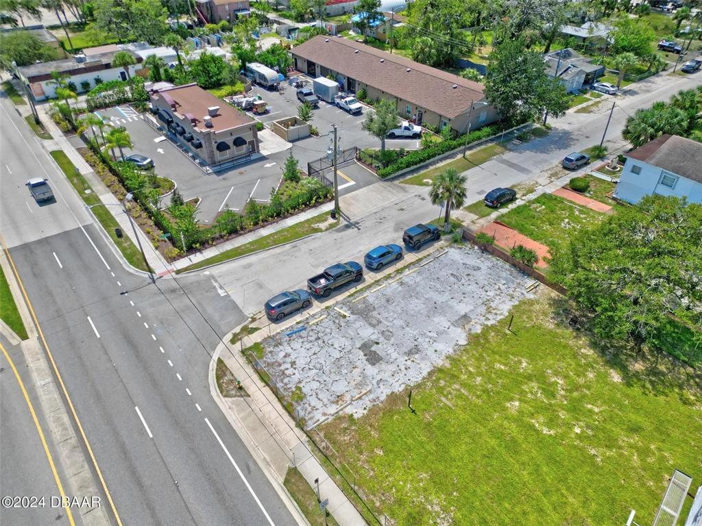An aerial view shows a vacant concrete lot adjacent to a paved parking area — RIDGEWOOD AVENUE, DAYTONA BEACH, FL