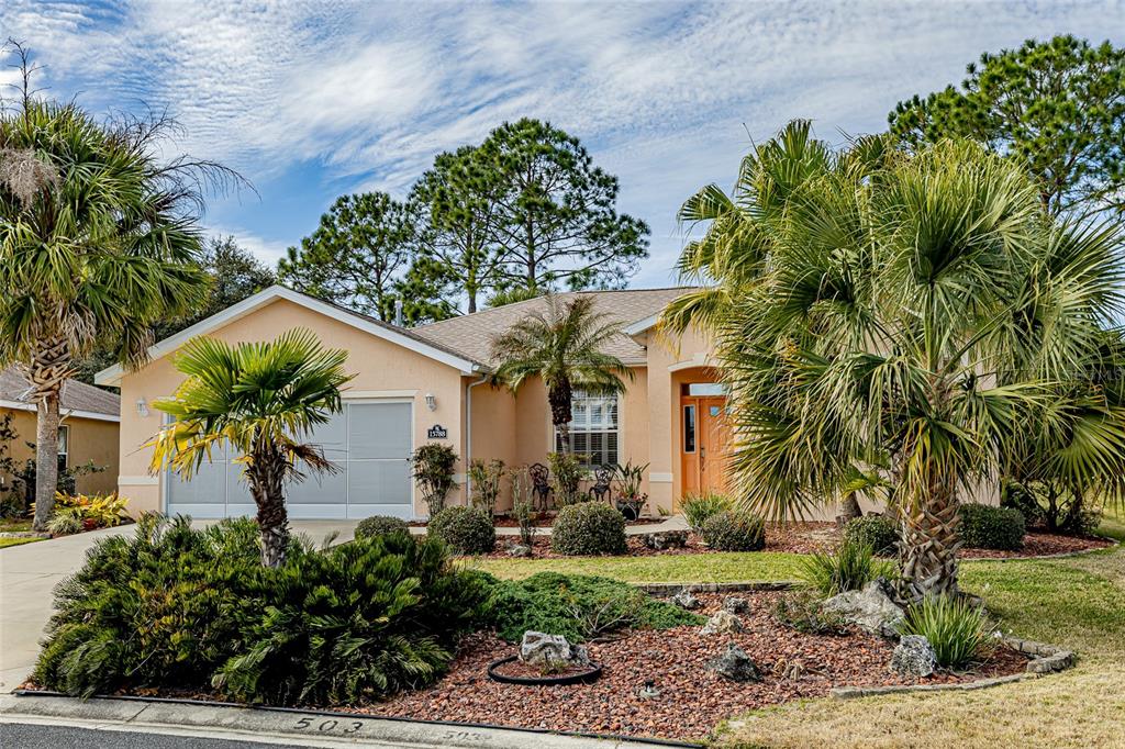 A single-story peach-colored house features a two-car garage, palm trees, and a landscaped front yard — 15788 SW 11TH TERRACE ROAD, OCALA, FL