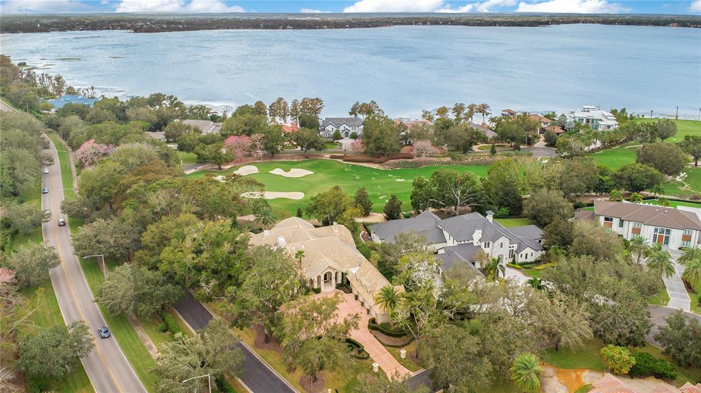 An aerial view shows a large house with a paved driveway near a golf course — 5524 WORSHAM COURT, WINDERMERE, FL
