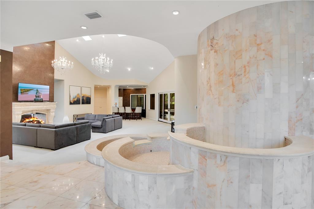A spacious living area features a large marble-tiled indoor spa, a fireplace, and chandeliers — 5524 WORSHAM COURT, WINDERMERE, FL