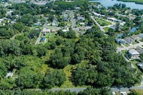 An aerial view shows a large, wooded vacant lot surrounded by residential houses and streets — 2801 11TH AVENUE E, BRADENTON, FL