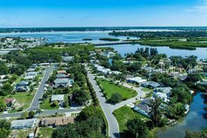 An aerial view shows a residential neighborhood situated along a coastal waterway and green space — 2801 11TH AVENUE E, BRADENTON, FL