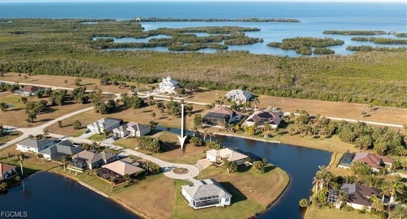 This aerial view shows a vacant residential lot in a waterfront community — 16219 CAYMAN LANE, PUNTA GORDA, FL