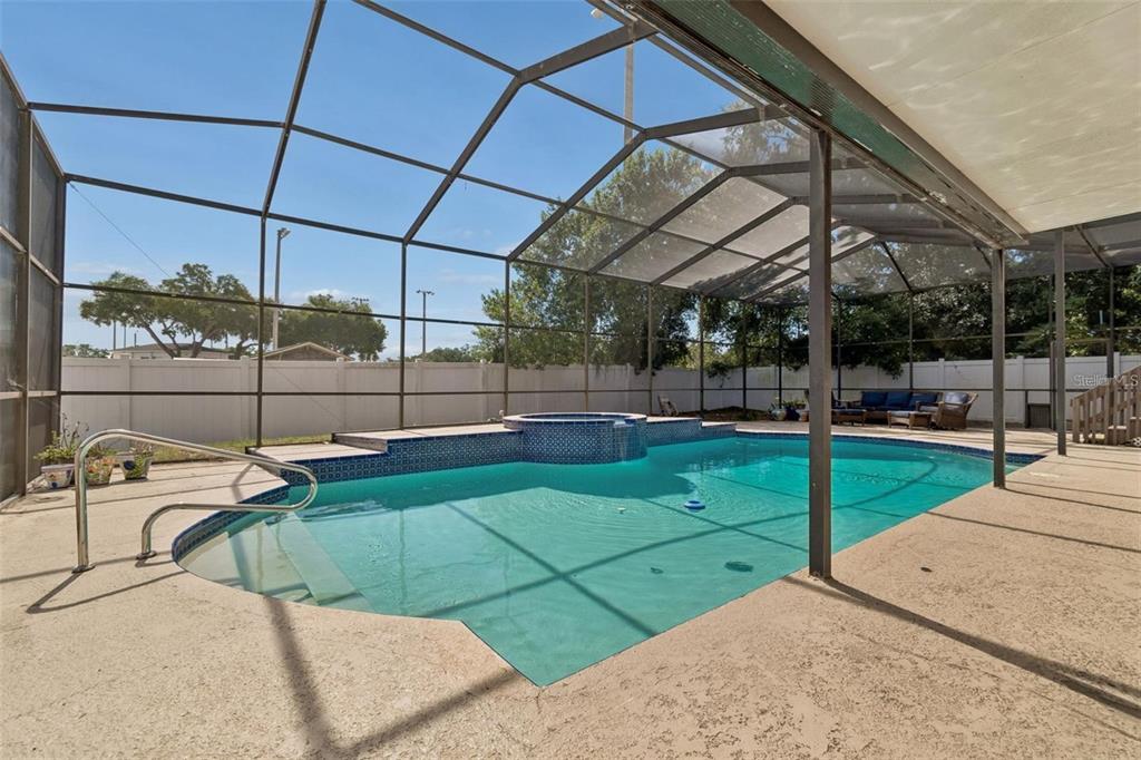 A screened-in swimming pool and hot tub on a concrete patio with a white fence — 2620 GIANT PLACE, SEFFNER, FL