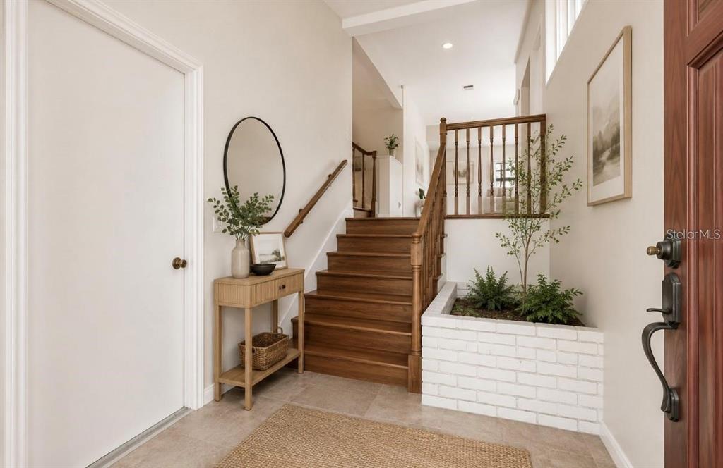 An entryway features a wooden staircase, a white brick planter, and a console table — 2620 GIANT PLACE, SEFFNER, FL