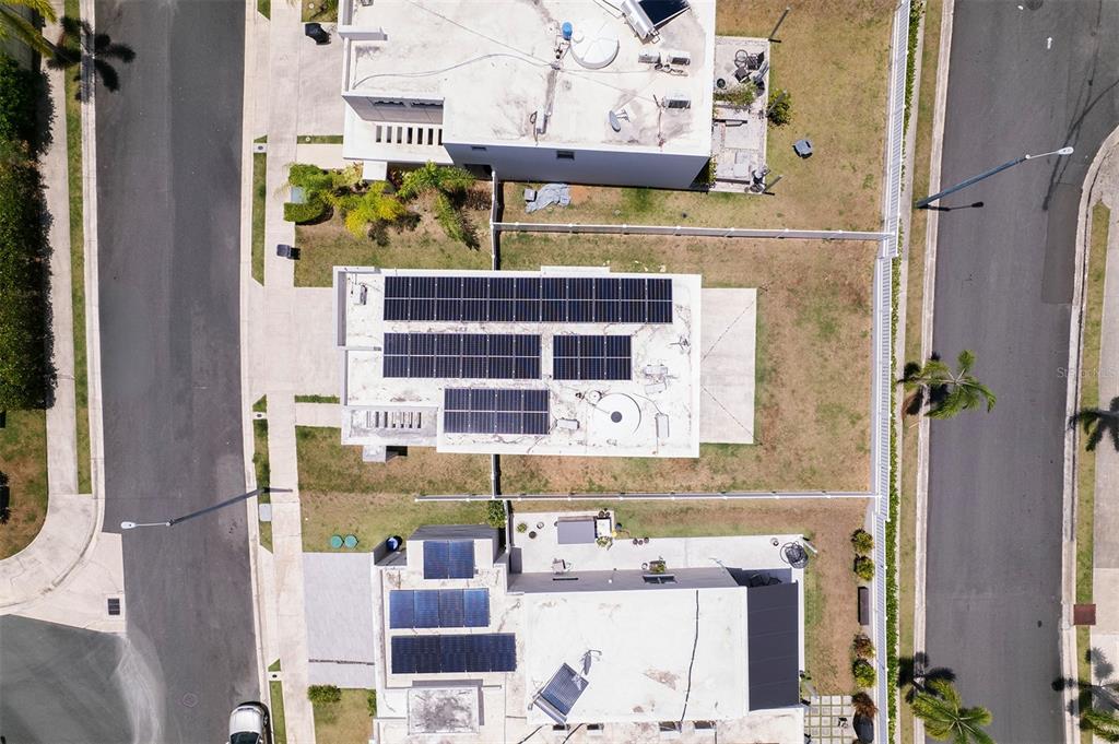 An aerial view shows three residential houses with solar panels on their flat roofs — Calle 13 UNIT 134, GUAYNABO, PR