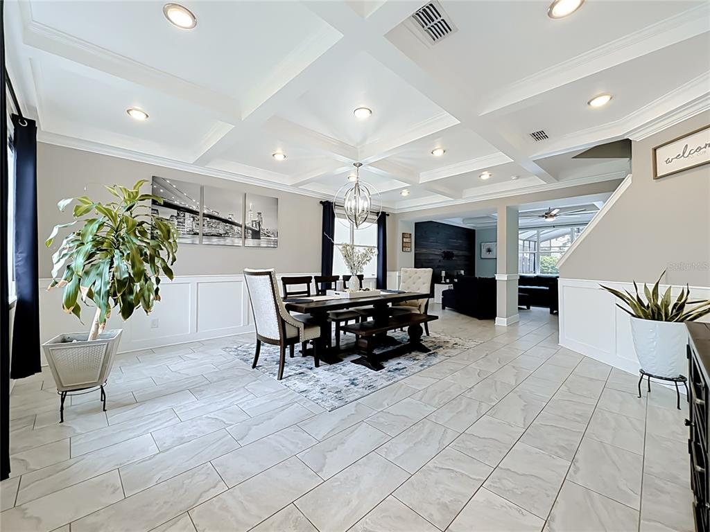 A dining room features a coffered ceiling, tile flooring, and wainscoting on the walls — 1515 BLUE HORIZON DRIVE, CLERMONT, FL
