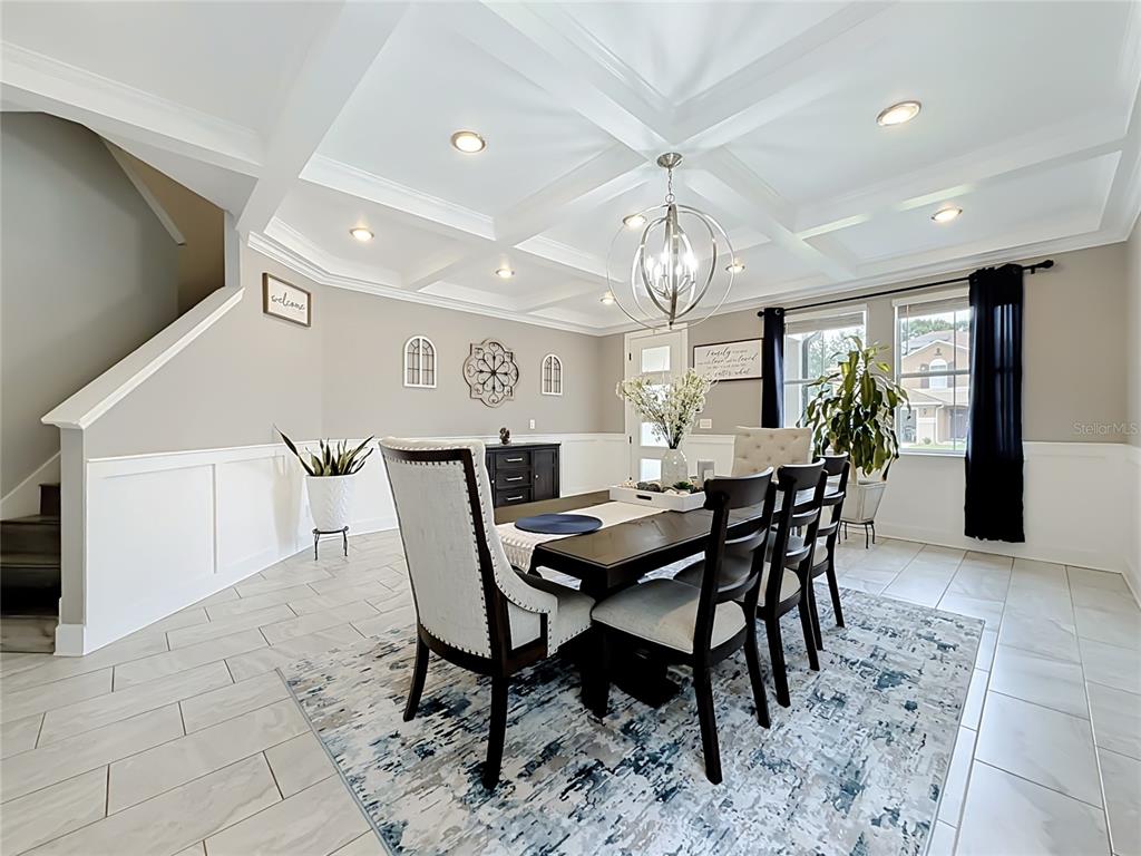 A dining room features a coffered ceiling, tile flooring, and a dark wood table set — 1515 BLUE HORIZON DRIVE, CLERMONT, FL