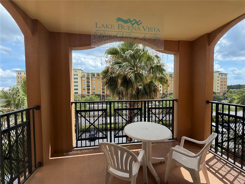 A balcony features a small round table, two white chairs, and a view of buildings — 8101 RESORT VILLAGE DRIVE UNIT 3411, ORLANDO, FL