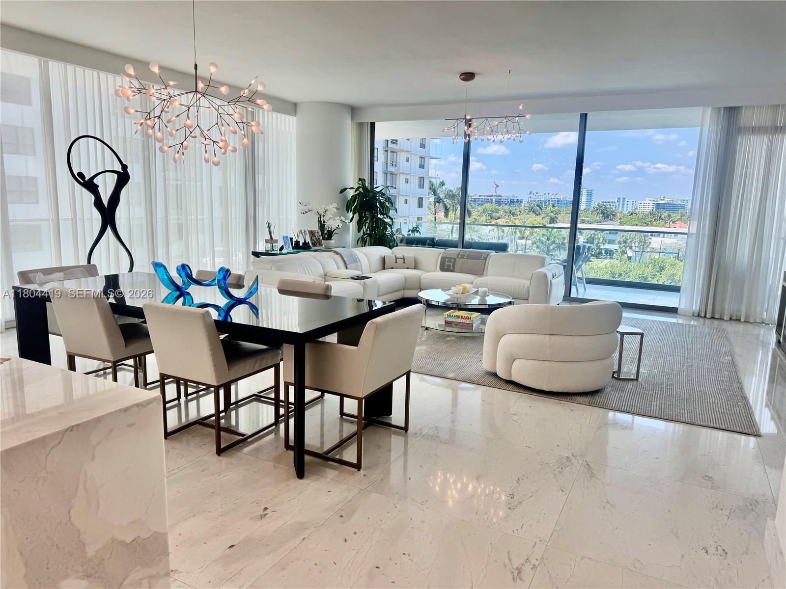 A modern open-concept living and dining area features marble floors, floor-to-ceiling windows, and contemporary furniture — 10201 Collins Ave # 511, Bal Harbour FL 33154, BAL HARBOUR, FL