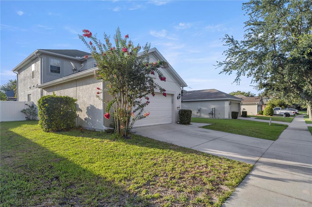 A two-story house with a white garage and a flowering tree in the front yard — 4073 SW 47TH COURT, OCALA, FL