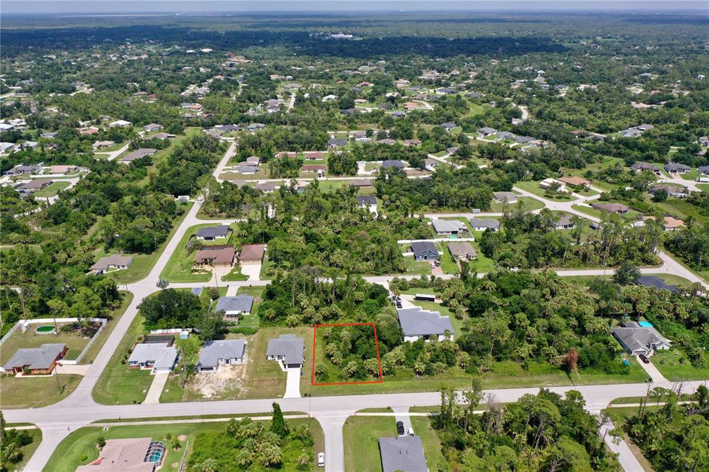 An aerial view shows a vacant, wooded residential lot outlined in red within a suburban neighborhood — NORDENDALE BOULEVARD, NORTH PORT, FL