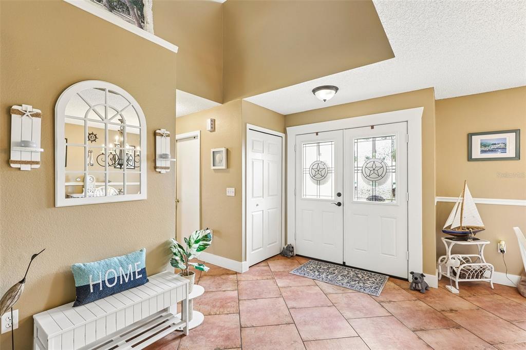 An entryway features a tiled floor, double front doors, and a white bench with decor — 17 PINELL LANE, PALM COAST, FL