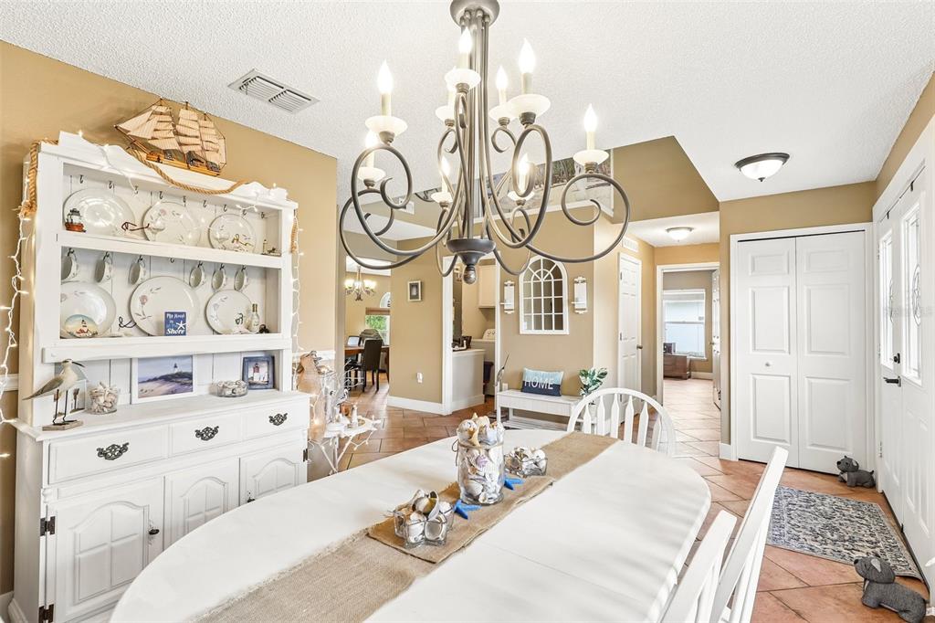 A dining room features a white hutch, a chandelier, and a table with coastal decor — 17 PINELL LANE, PALM COAST, FL
