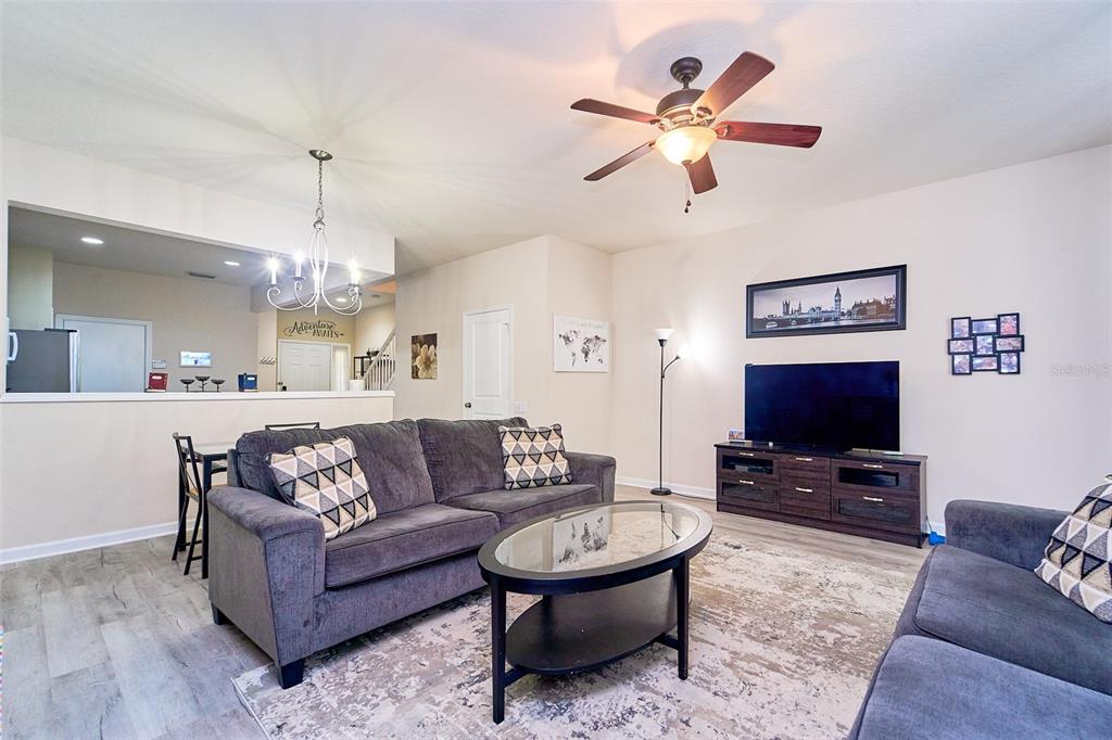 A living room features gray sofas, a glass coffee table, and a ceiling fan — 5014 POND RIDGE ROAD, RIVERVIEW, FL