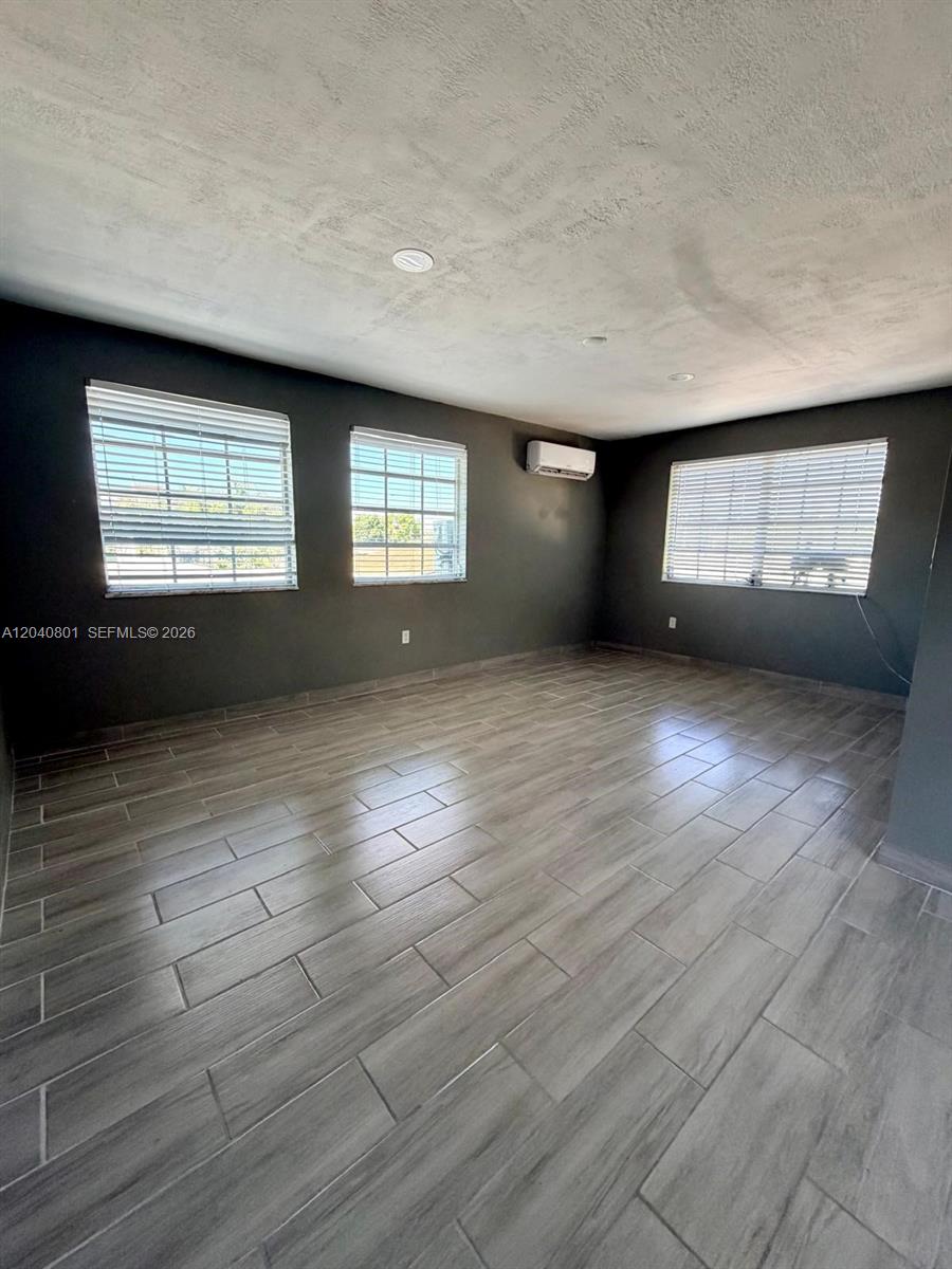 A kitchen area features a stainless steel refrigerator, a metal shelving unit, and tiled floors — 359 W 12th St # 3, Hialeah FL 33010, HIALEAH, FL