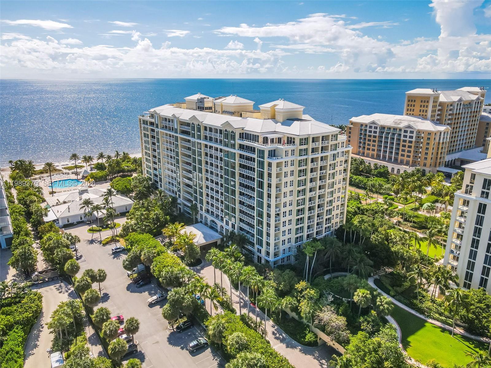 An aerial view shows a large multi-story residential building surrounded by lush landscaping and parking — 430 Grand Bay Dr # 307, Key Biscayne FL 33149, KEY BISCAYNE, FL
