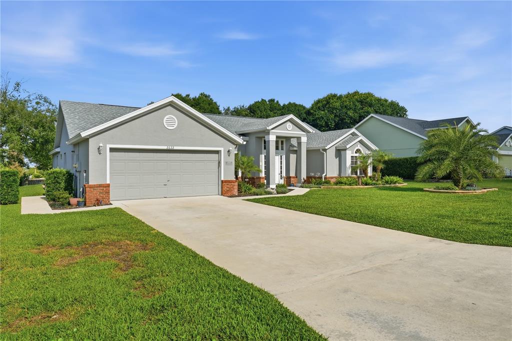 A single-story house with a gray exterior, a two-car garage, and a concrete driveway — 2622 MAYWOOD STREET, EUSTIS, FL