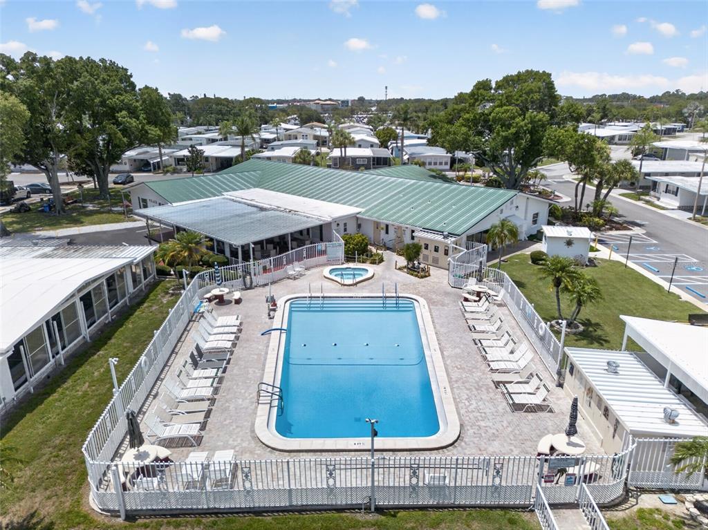 An aerial view of a swimming pool and hot tub surrounded by a fenced patio — 82221 F STREET N UNIT 221, PINELLAS PARK, FL