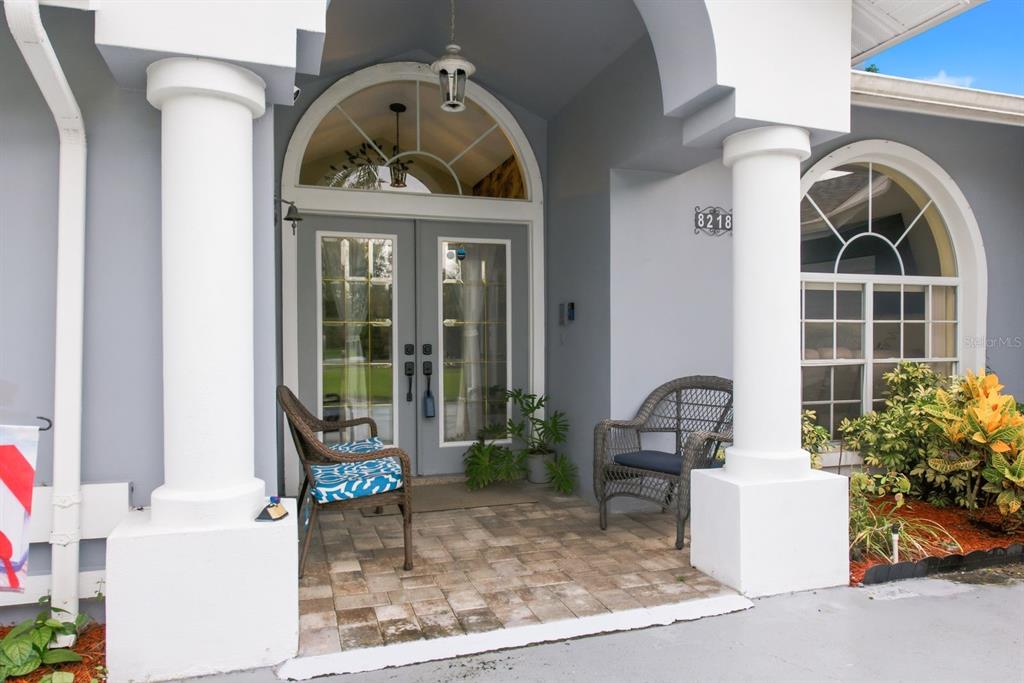 A kitchen with white cabinets, stainless steel appliances, and a view of the outdoor patio — 8218 MELISSA COURT, HUDSON, FL