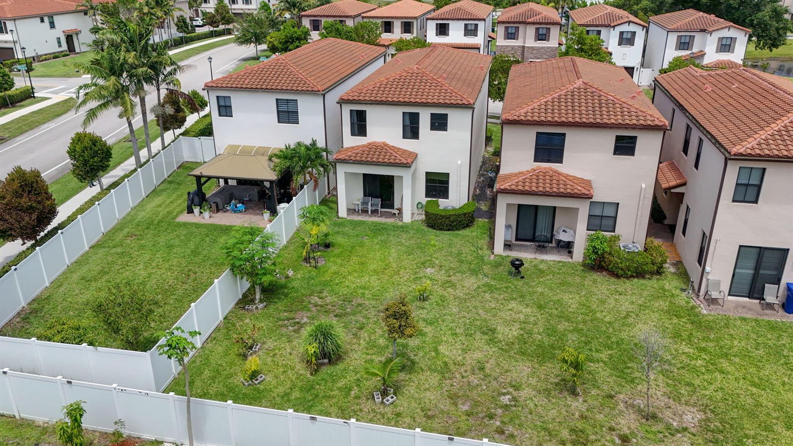 An aerial view shows the backyards and rear facades of several suburban two-story houses — 4009 Sequoia Place, Riviera Beach FL 33410, RIVIERA BEACH, FL