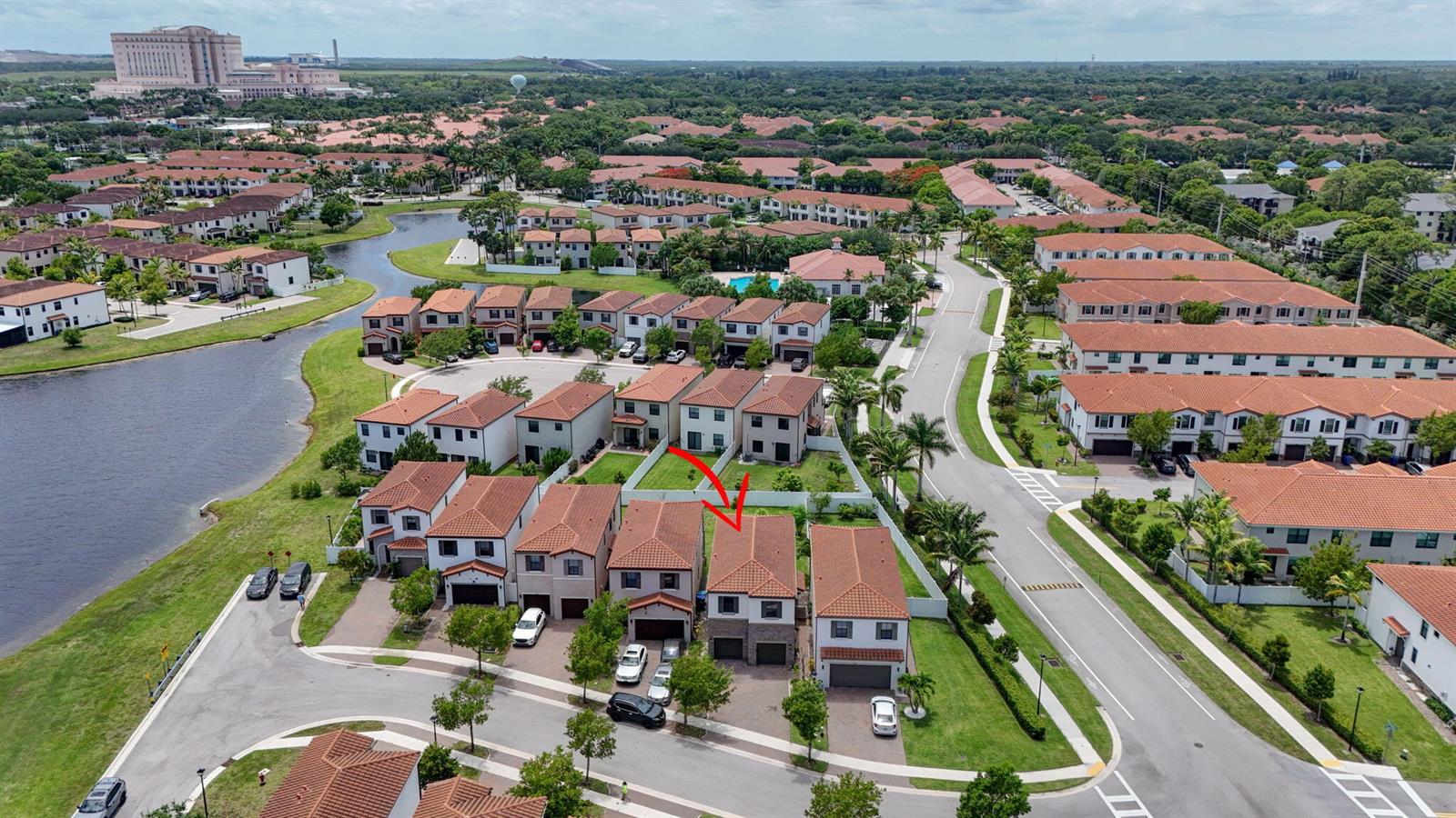 An aerial view shows a suburban neighborhood with two-story houses, a lake, and paved streets — 4009 Sequoia Place, Riviera Beach FL 33410, RIVIERA BEACH, FL
