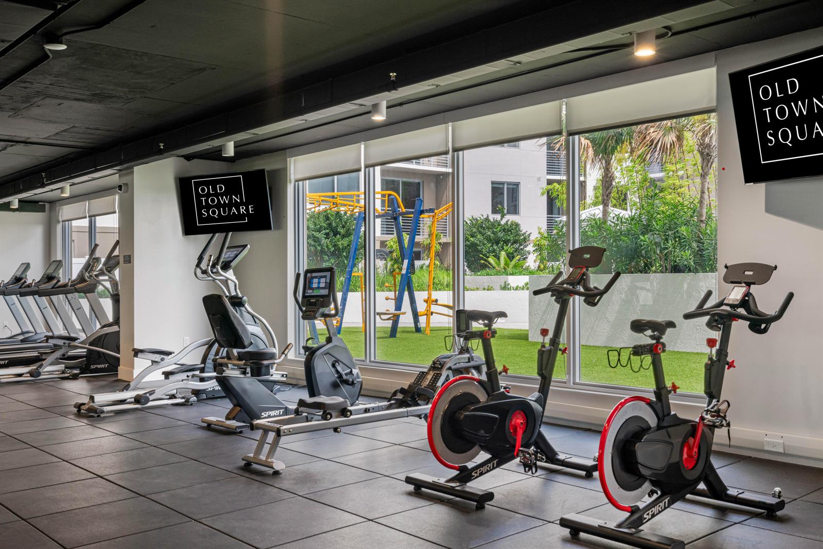 A fitness center with exercise equipment, black rubber flooring, and large windows overlooking a courtyard — 200 NE 1st Avenue # 109, Pompano Beach FL 33060, POMPANO BEACH, FL