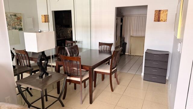 A dining area features a dark wood table with chairs and a matching side table — 5 Abbey Lane # 104, Delray Beach FL 33446, DELRAY BEACH, FL