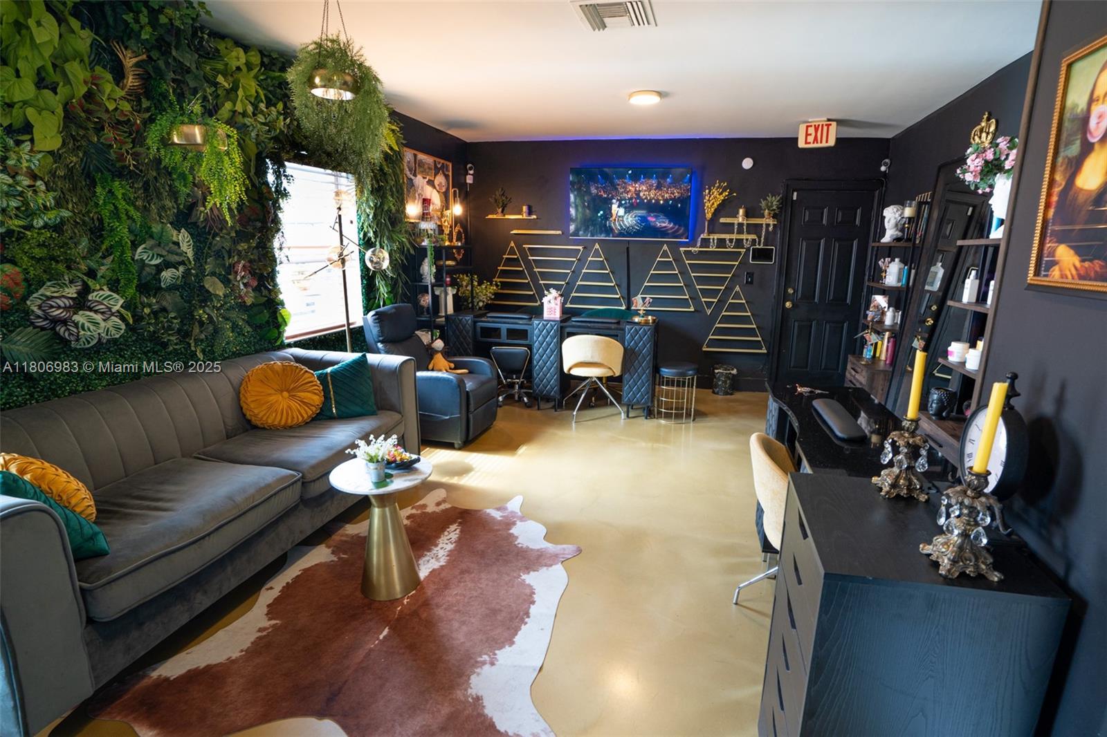 A modern studio room features a green wall, a grey sofa, and black workstation desks — 3436 N Miami Ave, Miami FL 33127, MIAMI, FL
