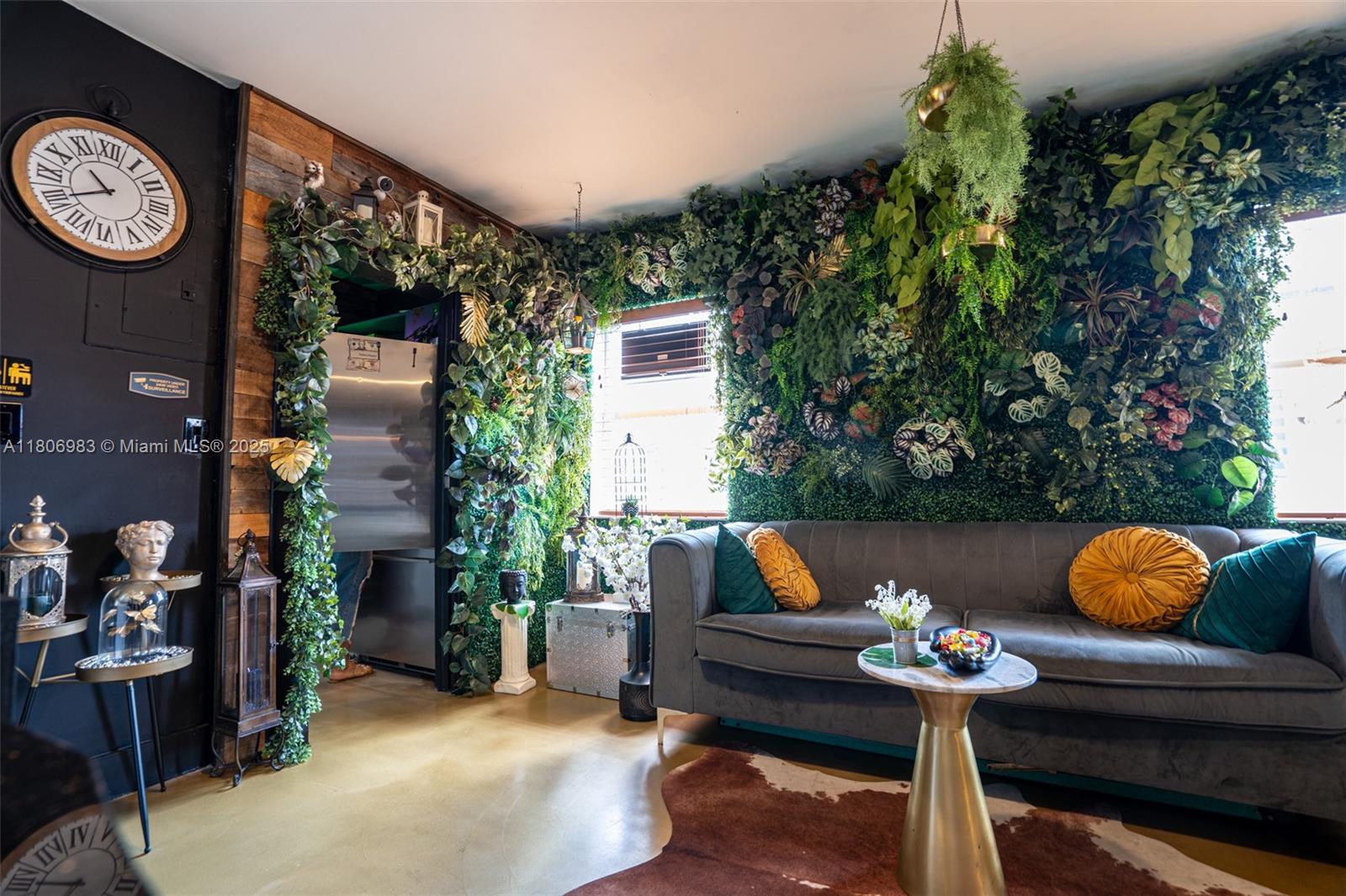 A living room features a large green wall, a grey sofa, and a round table — 3436 N Miami Ave, Miami FL 33127, MIAMI, FL