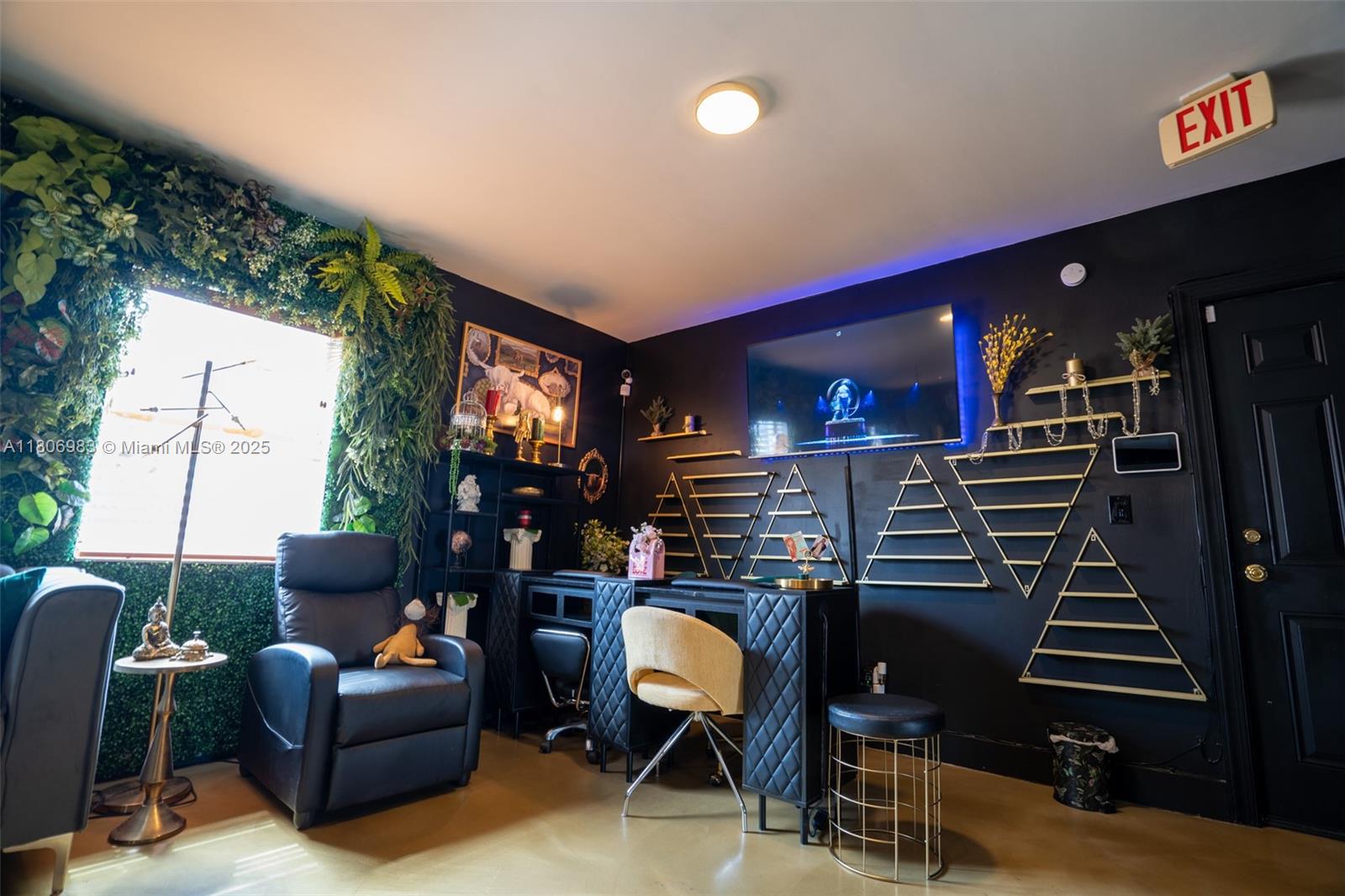 A black-walled office features a desk, a recliner, gold geometric wall decor, and greenery — 3436 N Miami Ave, Miami FL 33127, MIAMI, FL
