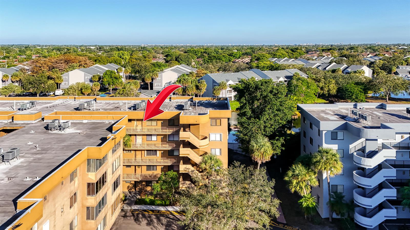 An aerial view of a multi-story apartment building with a red arrow pointing toward a balcony — 8030 Hampton Boulevard # 502, North Lauderdale FL 33068, NORTH LAUDERDALE, FL