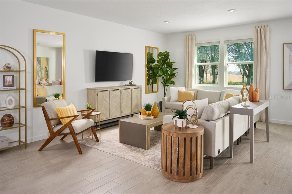 A living room features a television, a sofa, an armchair, and a wooden coffee table — 83 WANDERING CREEK WAY, PALM COAST, FL