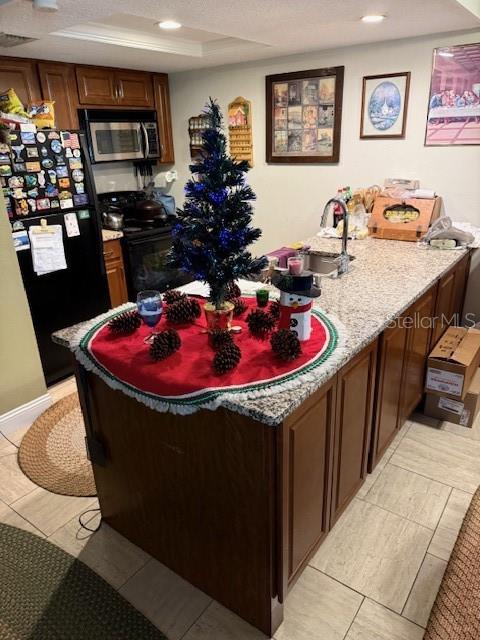 A kitchen island with a granite countertop features a small Christmas tree and holiday decor — 108 LACOSTA LANE UNIT 512, DAYTONA BEACH, FL