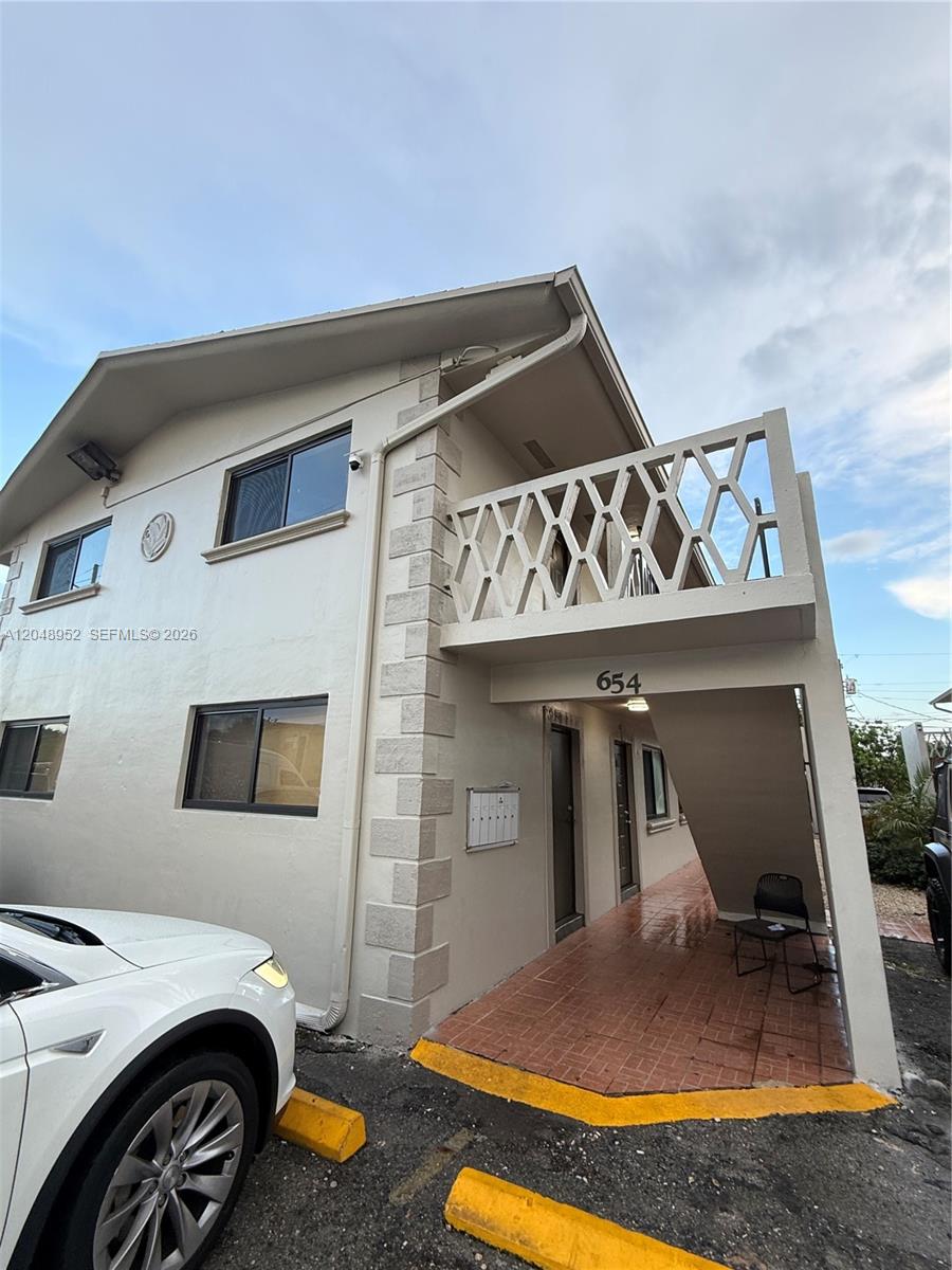 The exterior of a two-story apartment building features a balcony with a geometric railing — 654 W 29th St # 4, Hialeah FL 33012, HIALEAH, FL
