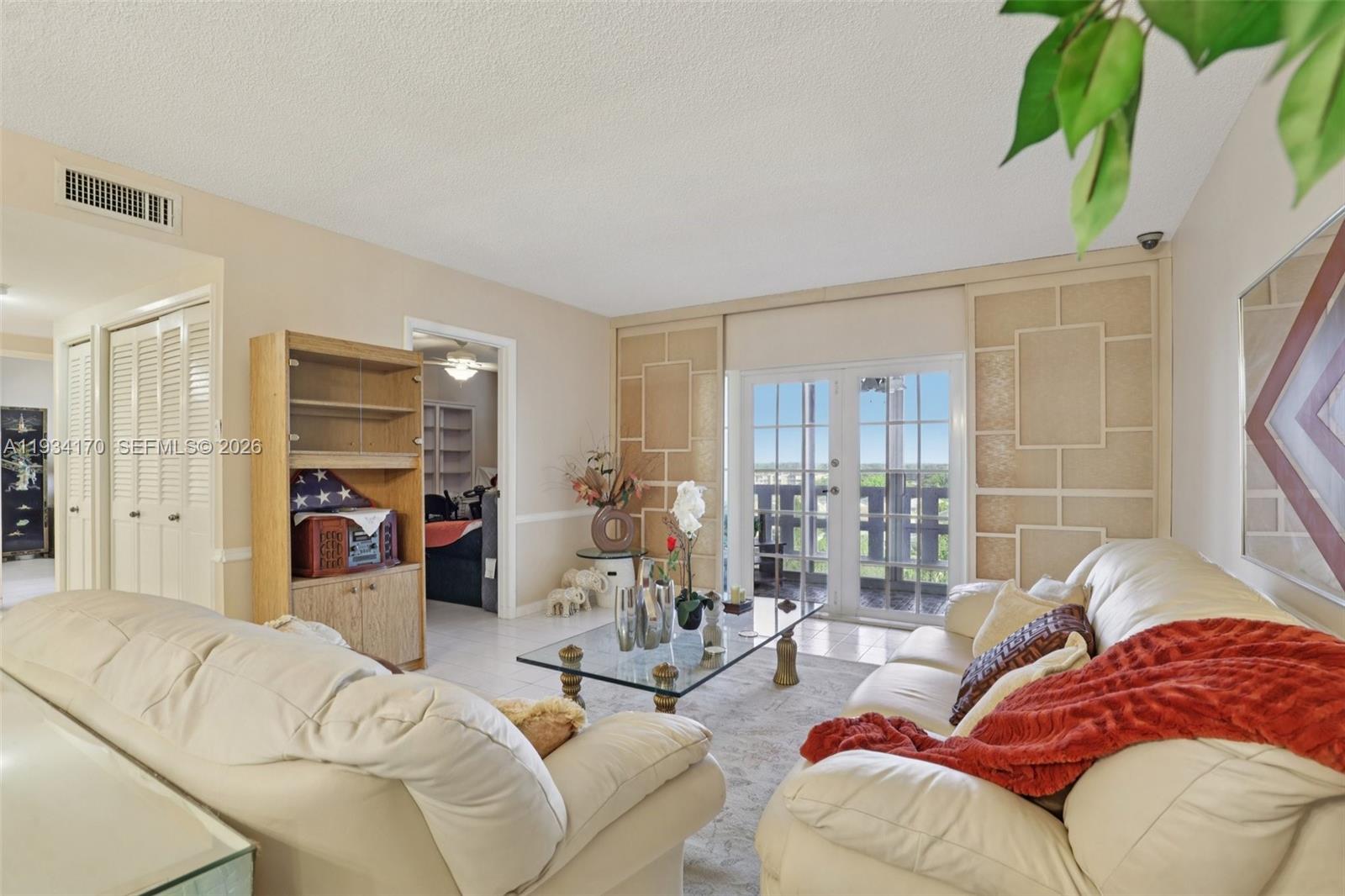 A living room features white leather sofas, a glass coffee table, and glass balcony doors — 4350 Hillcrest Dr # 702, Hollywood FL 33021, HOLLYWOOD, FL