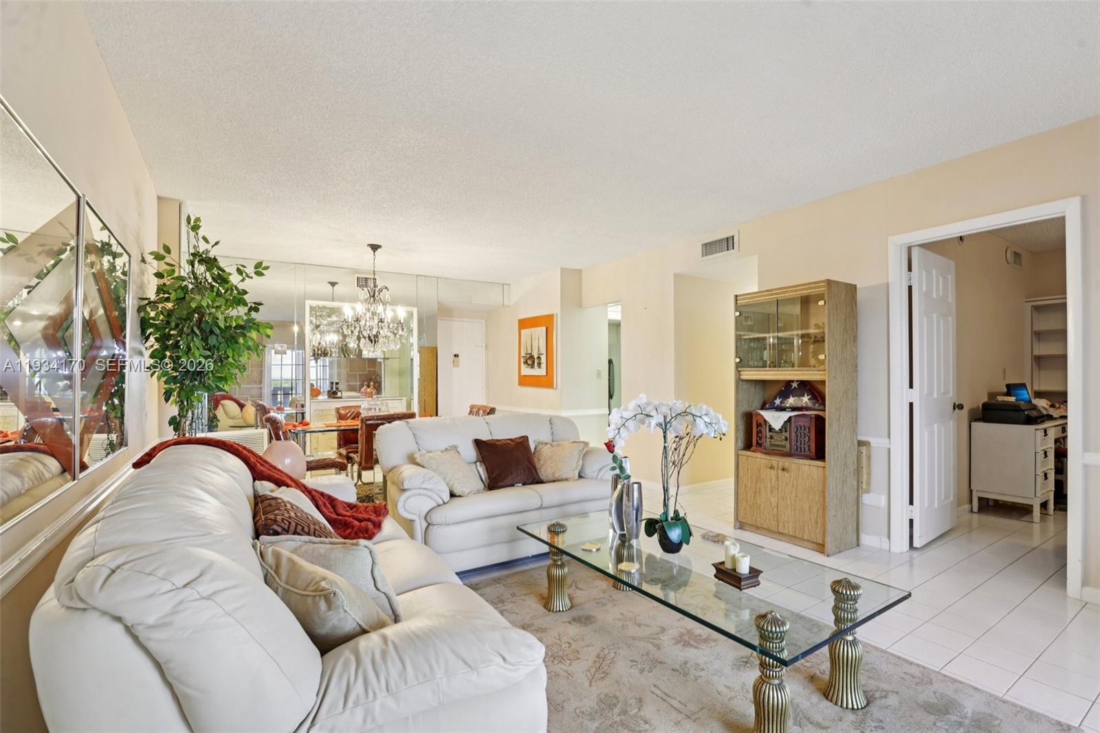 A living room features white leather sofas, a glass coffee table, and mirrored accent walls — 4350 Hillcrest Dr # 702, Hollywood FL 33021, HOLLYWOOD, FL