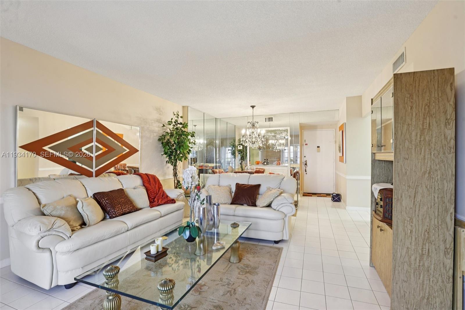 A living room features white leather sofas, a glass coffee table, and mirrored accent walls — 4350 Hillcrest Dr # 702, Hollywood FL 33021, HOLLYWOOD, FL