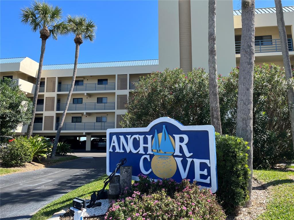 A sign for Anchor Cove stands in front of a multi-story apartment building with palm trees — 363 PINELLAS BAYWAY S UNIT 36, TIERRA VERDE, FL