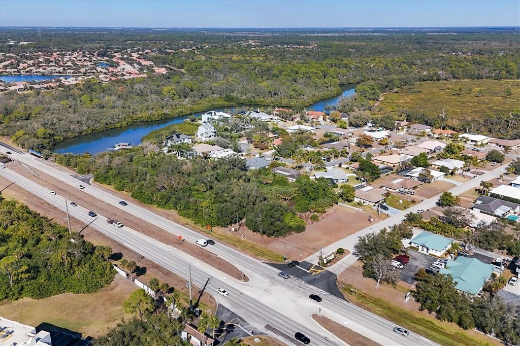 An aerial view shows a multi-lane highway bordering a residential neighborhood and a waterway — 2099 S TAMIAMI TRAIL, OSPREY, FL