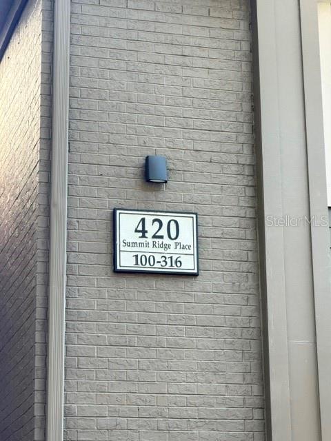 A sign on a gray brick wall displays the address 420 Summit Ridge Place — 420 SUMMIT RIDGE PLACE UNIT 310, LONGWOOD, FL