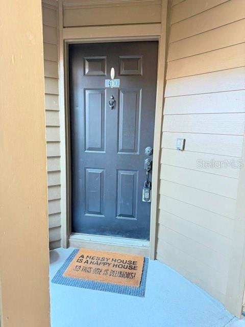 A dark brown front door with a keypad lock and a welcome mat — 420 SUMMIT RIDGE PLACE UNIT 310, LONGWOOD, FL