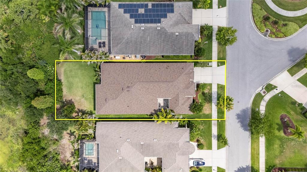 An aerial view shows a residential house with a large backyard and a driveway — 6411 BLUE SAIL LANE, APOLLO BEACH, FL