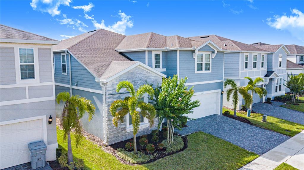 An exterior view of a two-story blue house with a stone facade and paved driveway — 2090 LELANI CIRCLE, DAVENPORT, FL