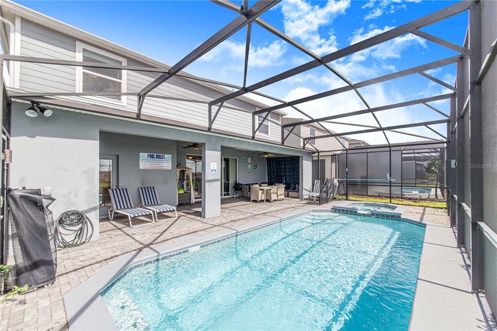 A screened-in patio features a swimming pool, a hot tub, and outdoor seating — 2090 LELANI CIRCLE, DAVENPORT, FL