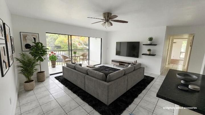 A living room features a grey sectional sofa, a black rug, and a sliding glass door — 517 Dotterel Road # 31c, Delray Beach FL 33444, DELRAY BEACH, FL