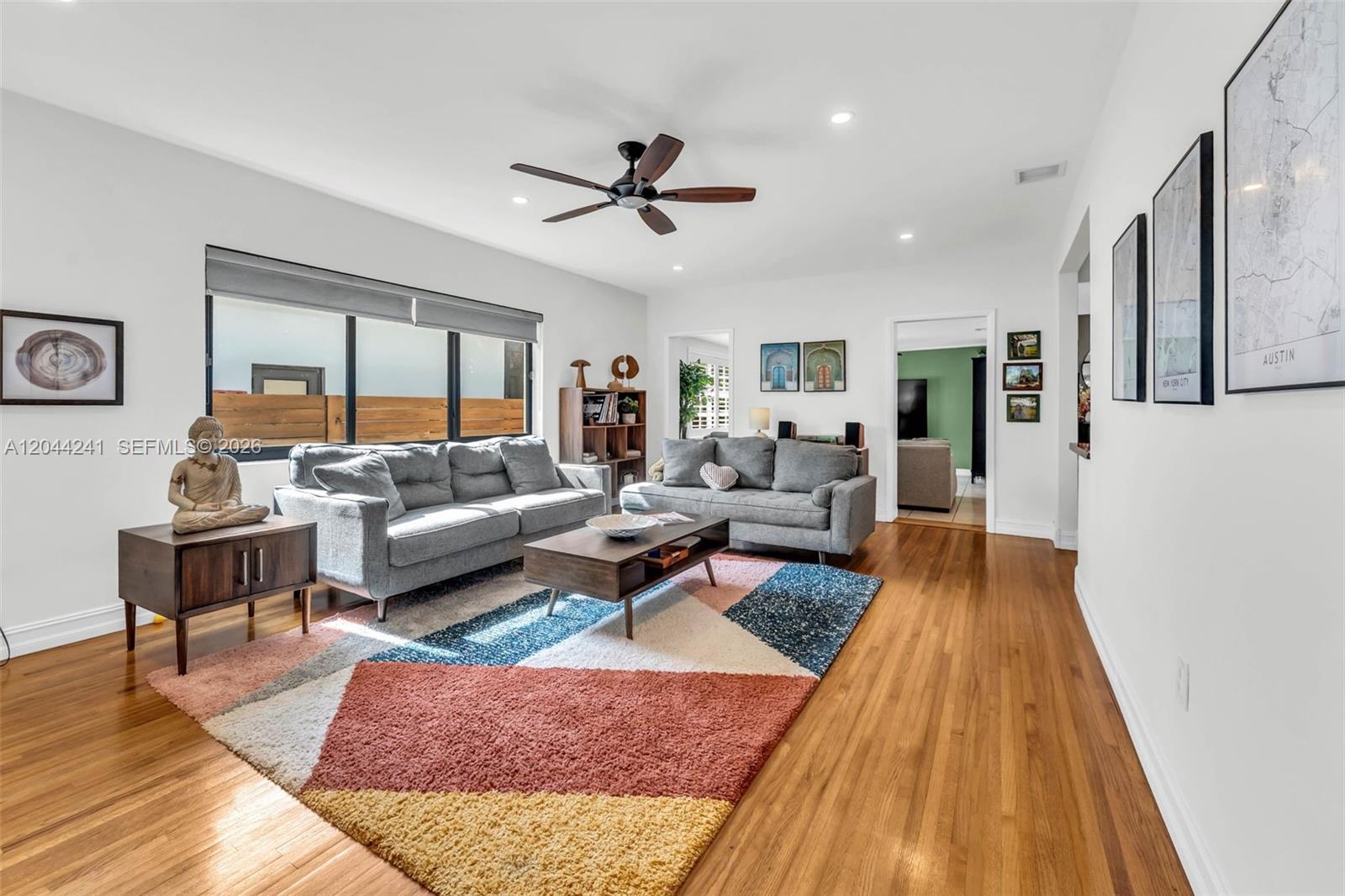 A living room features two gray sofas, a geometric rug, and hardwood floors — 2220 SW 25th St, Miami FL 33133, MIAMI, FL