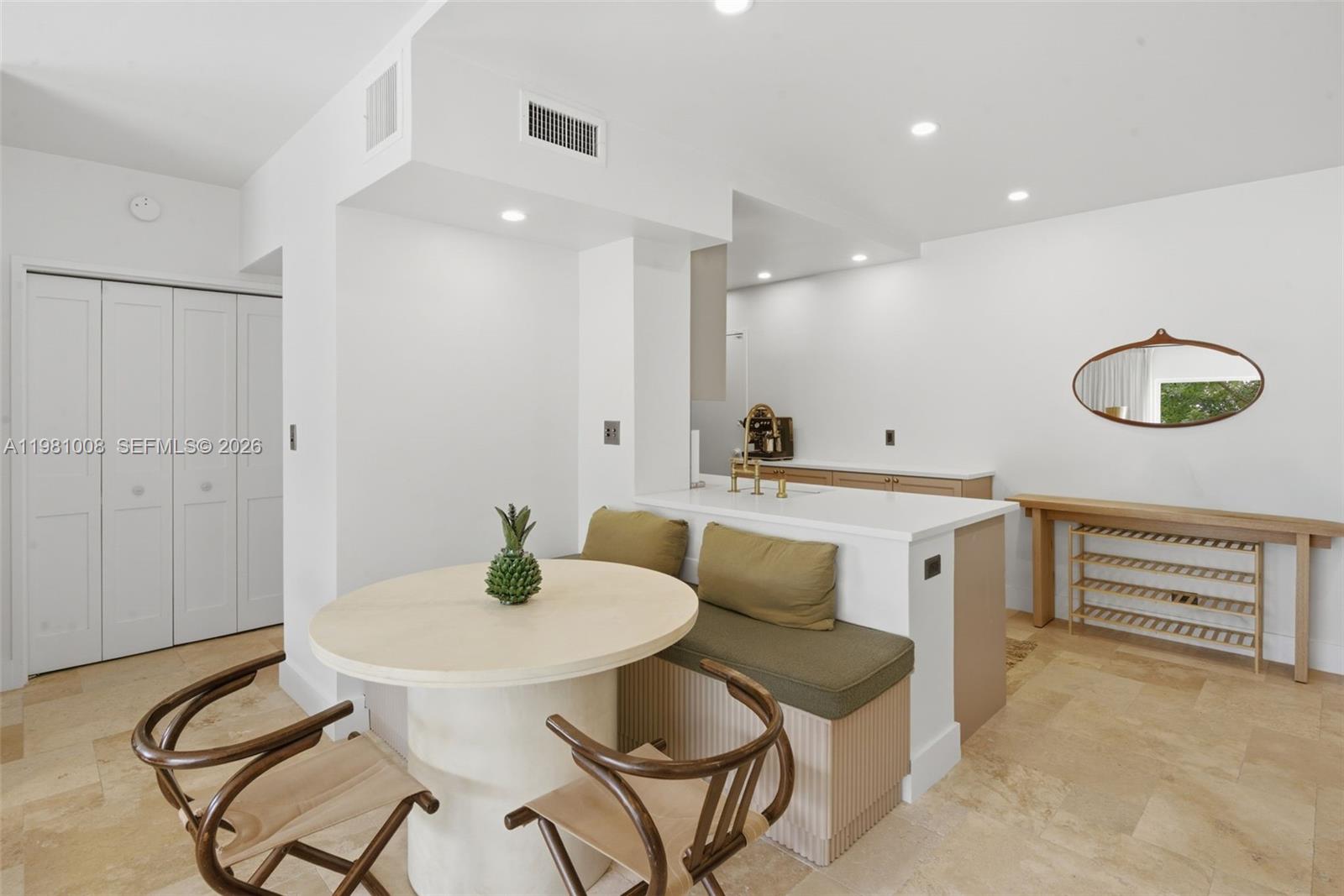 A dining area features a round table, a built-in bench, and a kitchen counter — 3 Island Ave # 06K, Miami Beach FL 33139, MIAMI BEACH, FL