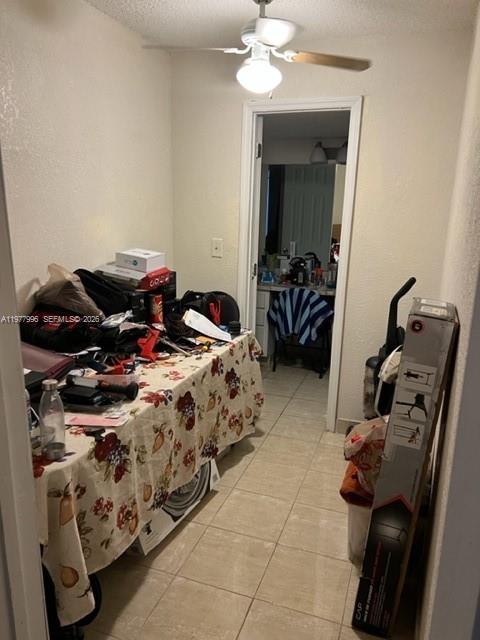 A narrow laundry room features a table covered with items and a ceiling fan — 2029 NW 46th Ave # E503, Lauderhill FL 33313, LAUDERHILL, FL